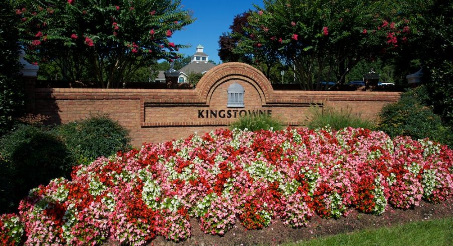 A charming entrance sign in Kingstowne adorned with stunning flowers.