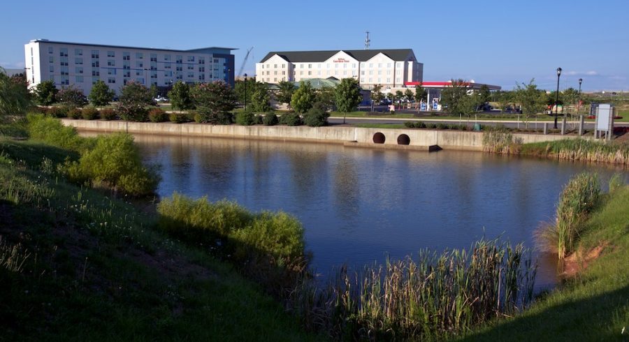 A captivating view of the Hilton Garden Inn situated at the Dulles Parkway Center, overlooking a serene pond.
