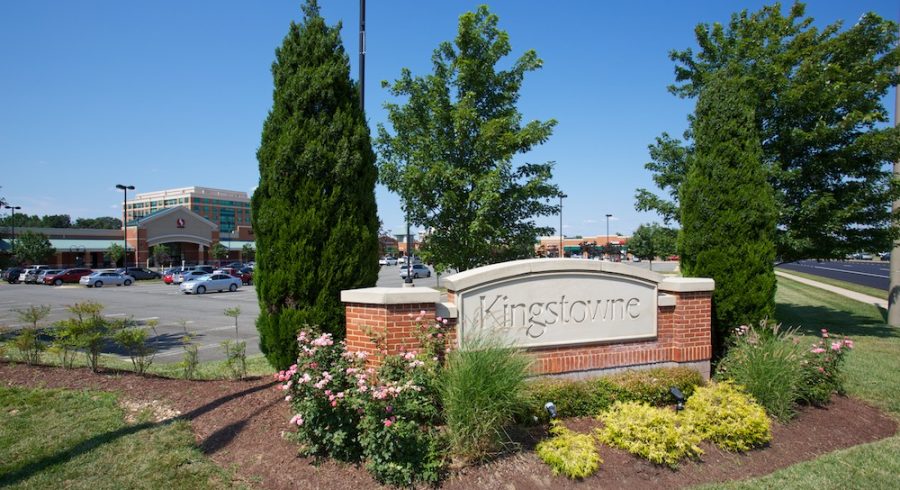 A scenic view of the Kingstowne shopping center entrance sign framed by a beautifully landscaped environment.